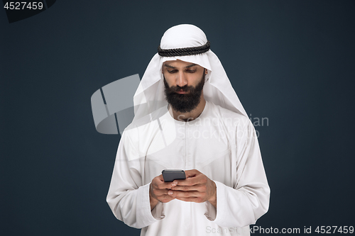 Image of Arabian saudi man on dark blue studio background