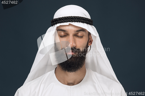 Image of Arabian saudi man on dark blue studio background