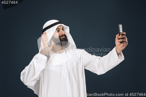 Image of Arabian saudi man on dark blue studio background