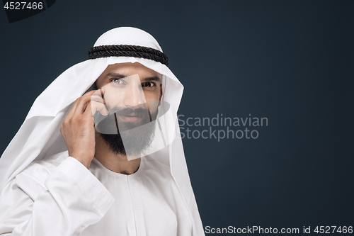 Image of Arabian saudi man on dark blue studio background