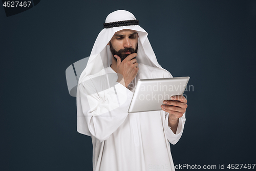 Image of Arabian saudi businessman on dark blue studio background