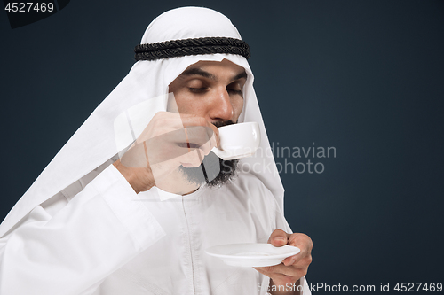 Image of Arabian saudi man on dark blue studio background