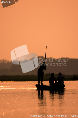 Image of Blurred Men in a boat on a river silhouette