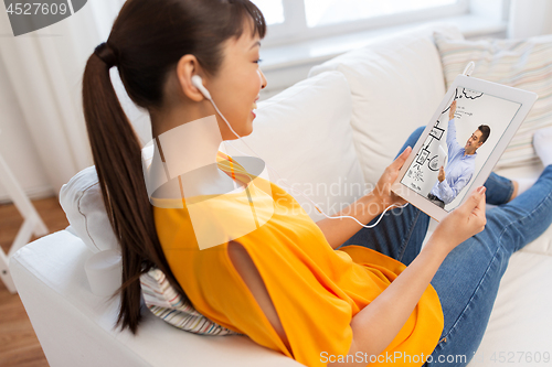 Image of woman watching webinar on tablet computer at home