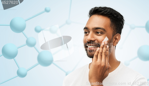 Image of indian man applying cream to face gel