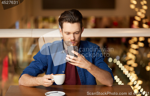 Image of man with coffee and smartphone at restaurant