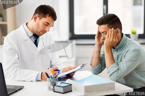 Image of doctor with clipboard and male patient at hospital