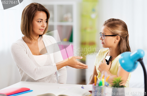 Image of displeased mother taking smartphone from daughter