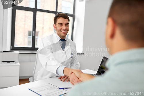 Image of doctor and male patient shaking hands at hospital