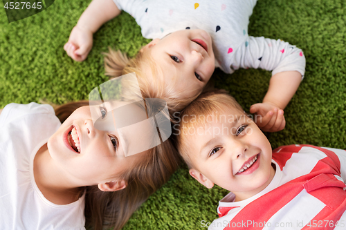 Image of happy little kids lying on floor or carpet