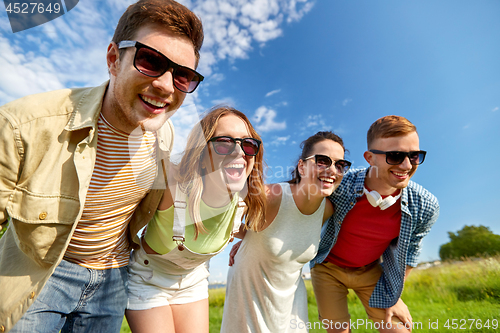 Image of happy teenage friends laughing outdoors in summer