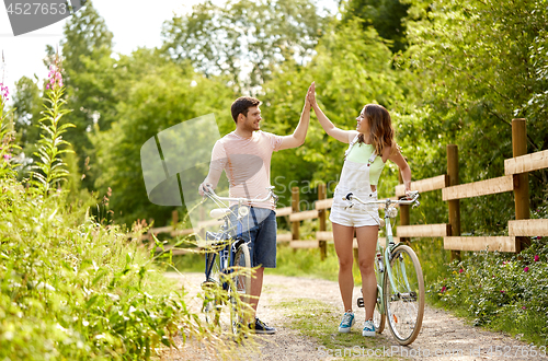 Image of happy couple with bicycles at summer park