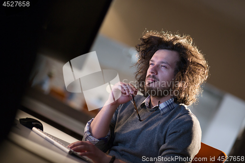 Image of man working on computer in dark office