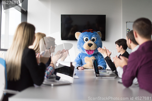 Image of boss dresed as bear having fun with business people in trendy of