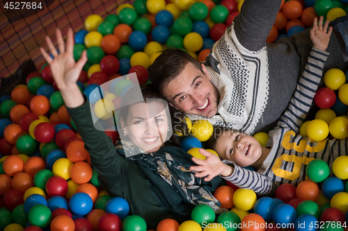 Image of young parents with kids in a children\'s playroom