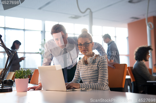 Image of Two Business People Working With laptop in office