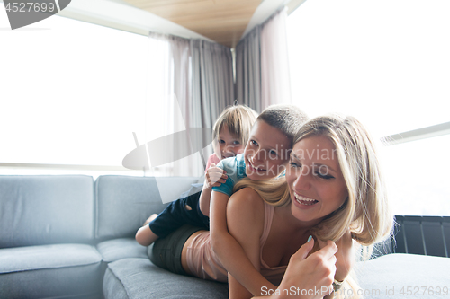 Image of young mother spending time with kids on the floor
