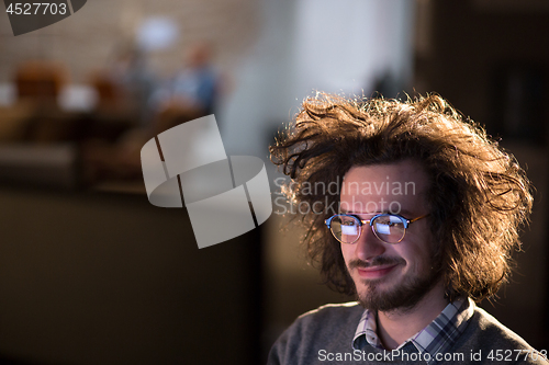 Image of man working on computer in dark office