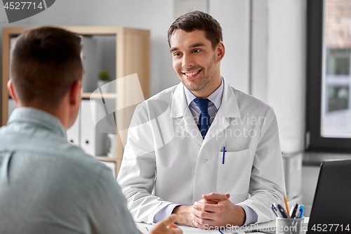 Image of smiling doctor talking to male patient at hospital