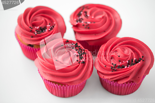 Image of close up of cupcakes with red buttercream frosting