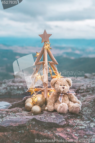 Image of Christmas tree with golden star lights against mountain backdrop