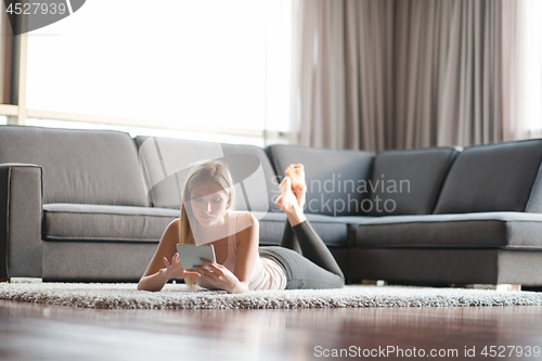 Image of young women using tablet computer on the floor