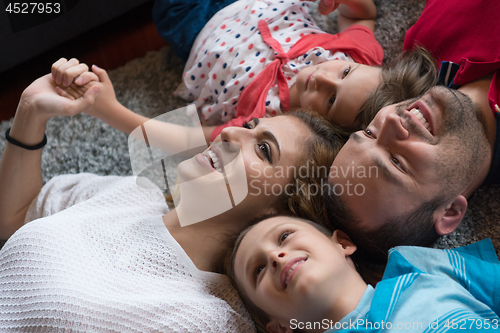 Image of happy family lying on the floor