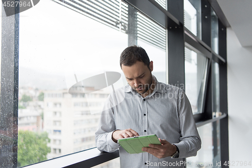 Image of Businessman Using Tablet In Office Building by window