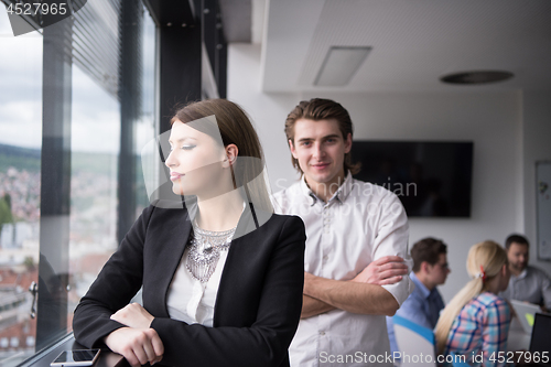 Image of Elegant Woman Using Mobile Phone by window in office building