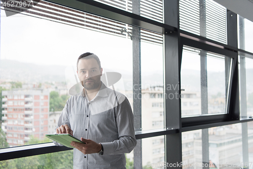 Image of Businessman Using Tablet In Office Building by window
