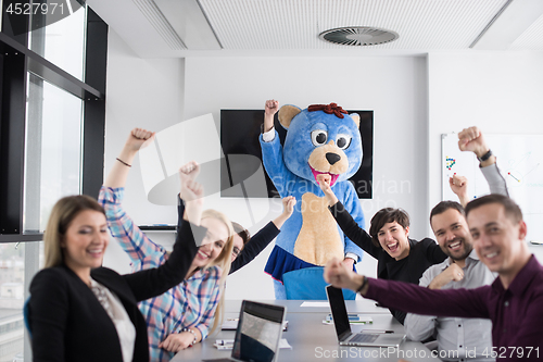 Image of boss dresed as bear having fun with business people in trendy of