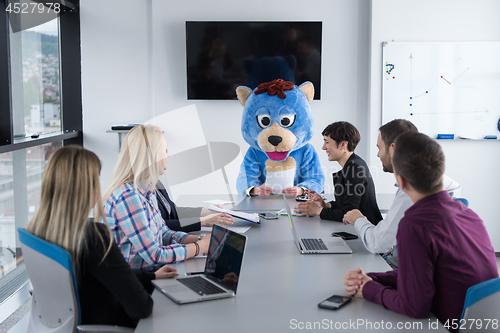 Image of boss dresed as bear having fun with business people in trendy of