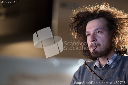 Image of man working on computer in dark office