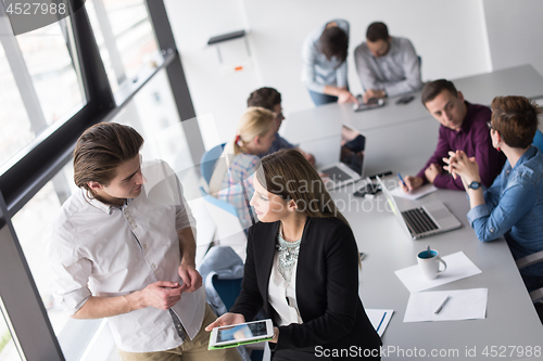 Image of Two Business People Working With Tablet in office