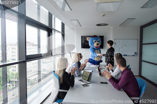 Image of boss dresed as bear having fun with business people in trendy of