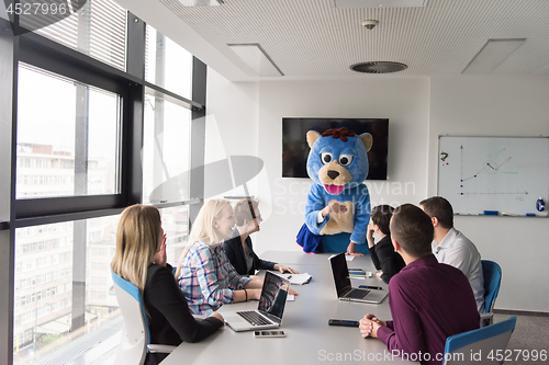 Image of boss dresed as bear having fun with business people in trendy of