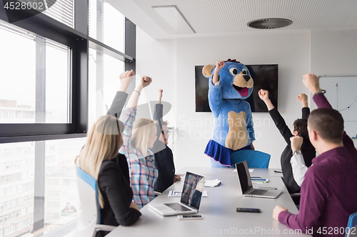 Image of boss dresed as bear having fun with business people in trendy of