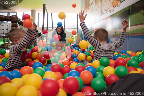 Image of Young mom with her kids in a children\'s playroom