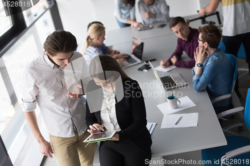 Image of Two Business People Working With Tablet in office