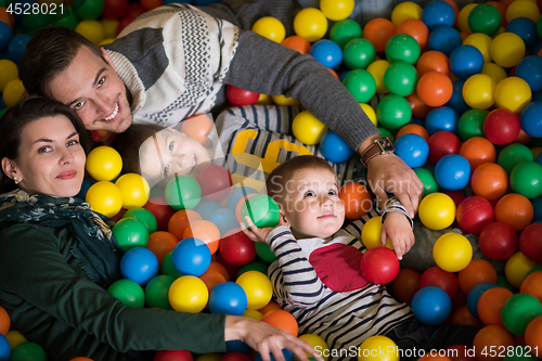 Image of young parents with kids in a children\'s playroom