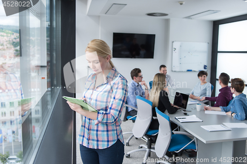 Image of Pretty Businesswoman Using Tablet In Office Building by window