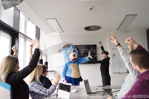 Image of boss dresed as bear having fun with business people in trendy of