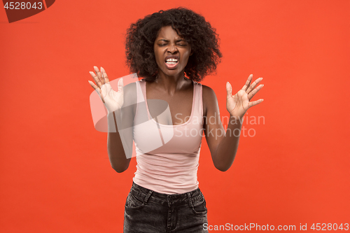 Image of Beautiful female half-length portrait isolated on red studio backgroud. The young emotional surprised woman