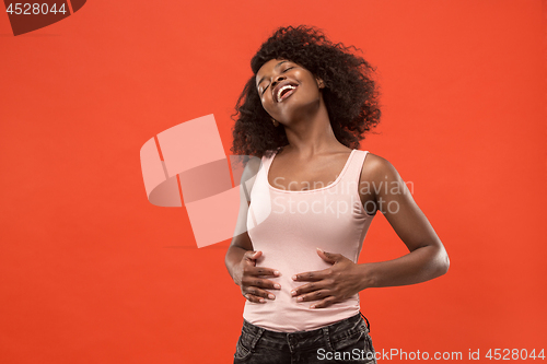 Image of The happy business woman standing and smiling against red background.