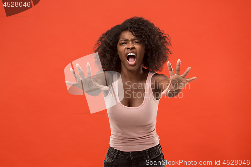 Image of The young emotional angry woman screaming on red studio background