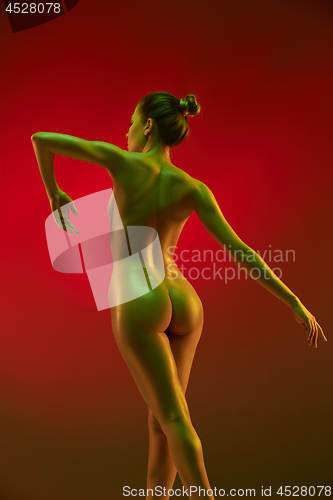 Image of fashion art photo of elegant nude model in the light colored spotlights