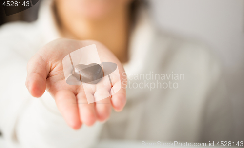 Image of close up of hand with heart shaped chocolate candy