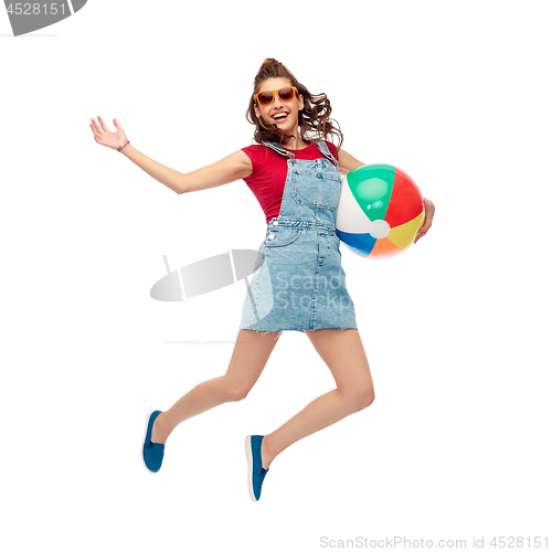 Image of teenage girl in sunglasses jumping with beach ball
