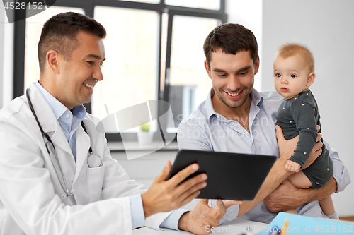 Image of father with baby and doctor with tablet at clinic