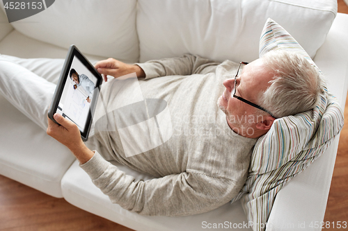 Image of senior man watching webinar on tablet at home